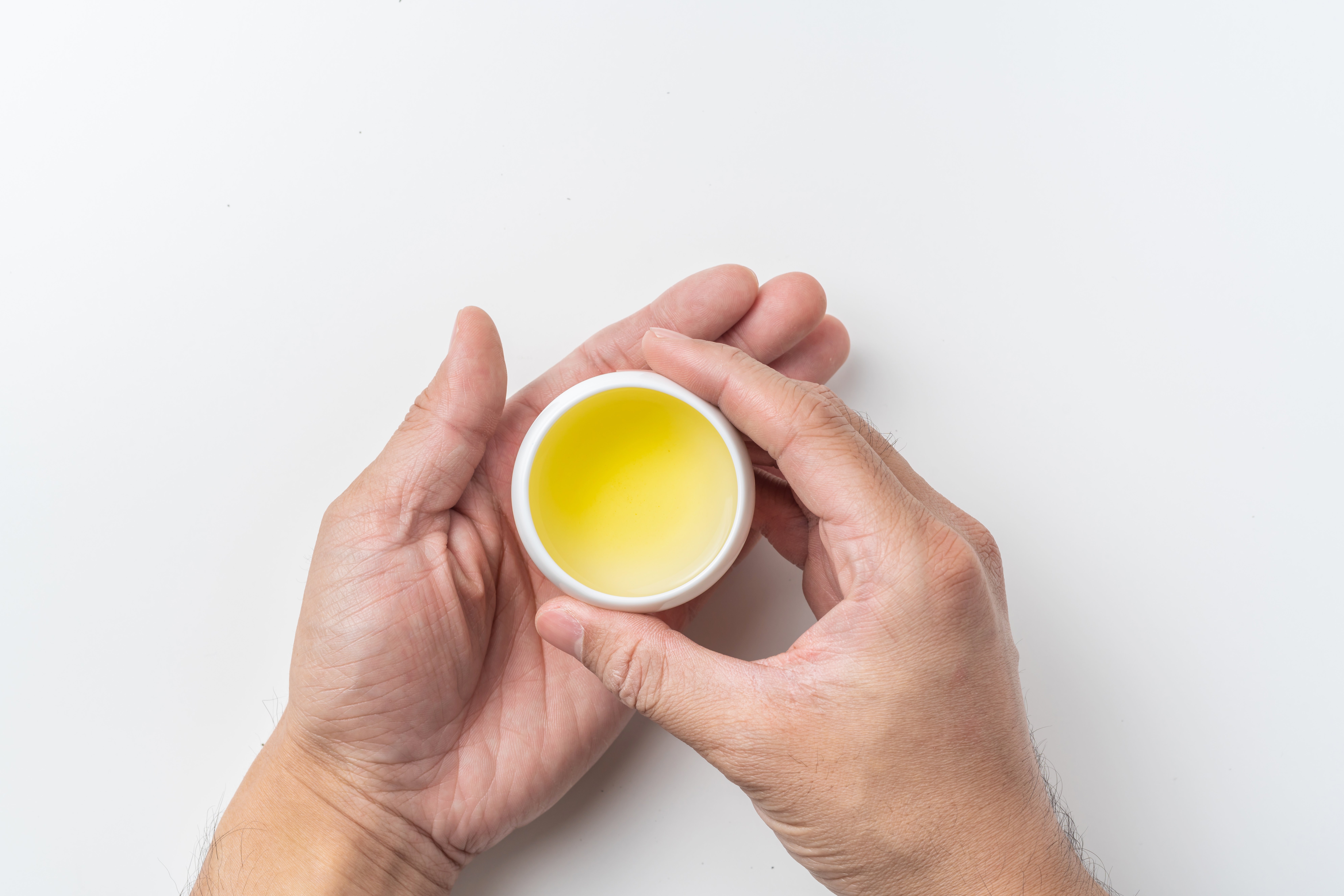 Asia culture and design concept - man's hand hold fresh taiwan oolong tea cup